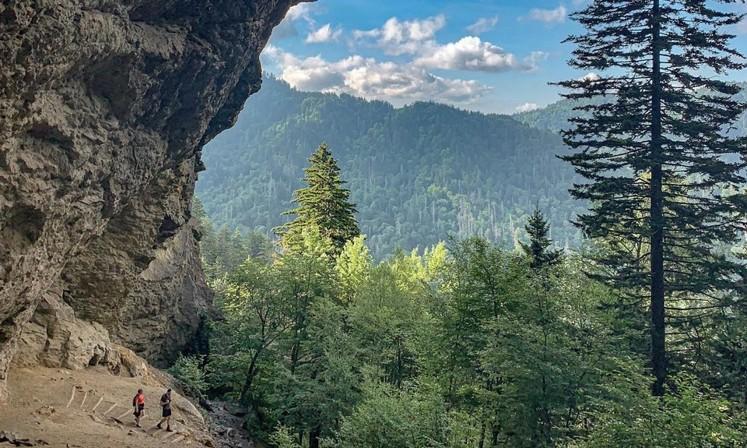Hikers below a rocky Smoky Mountains overlook