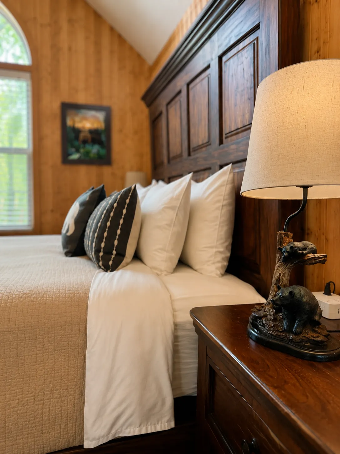 Cozy cabin bedroom with warm wood walls and bedside lamp